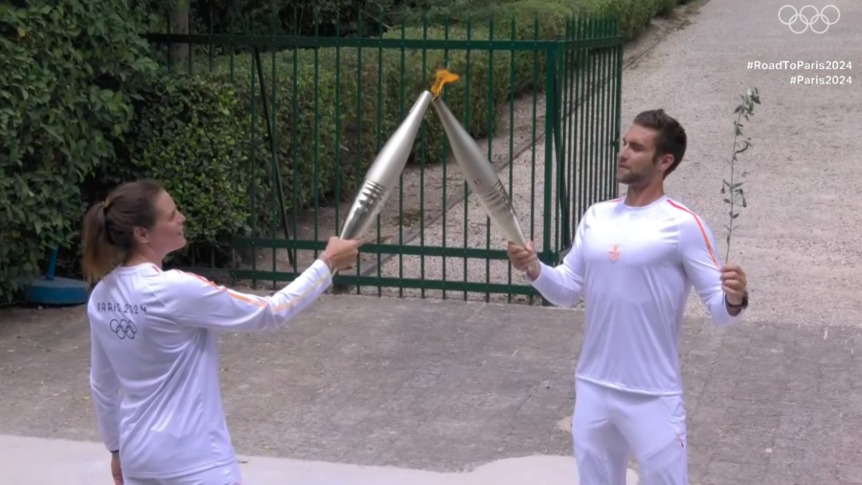 Le passage de relais entre le rameur grec Stefanos Ntouskos et la nageuse française Laure Manaudou, première relayeuse française de la flamme olympique.