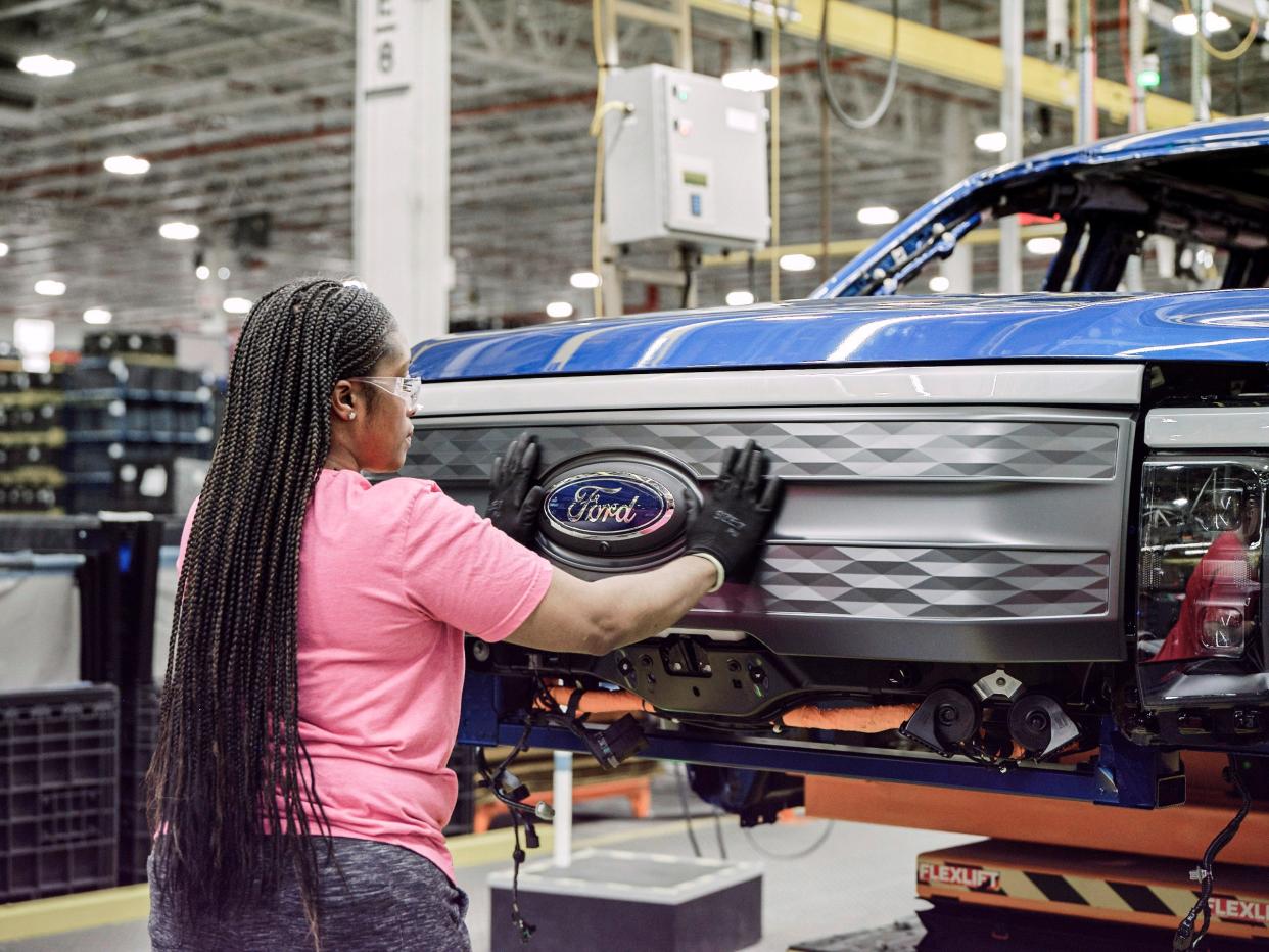 A Ford assembly worker with an electric F-150 Lightning
