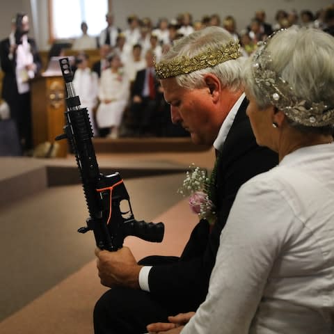 Members carry guns while some wear crowns, often made of bullets - Credit: Spencer Platt/Getty