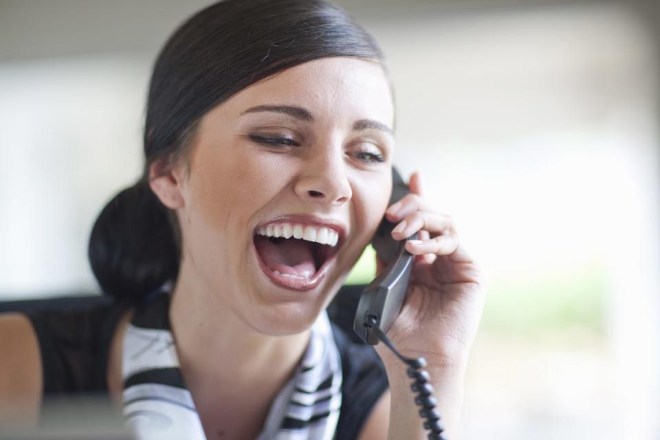 Young office worker talking on landline handset