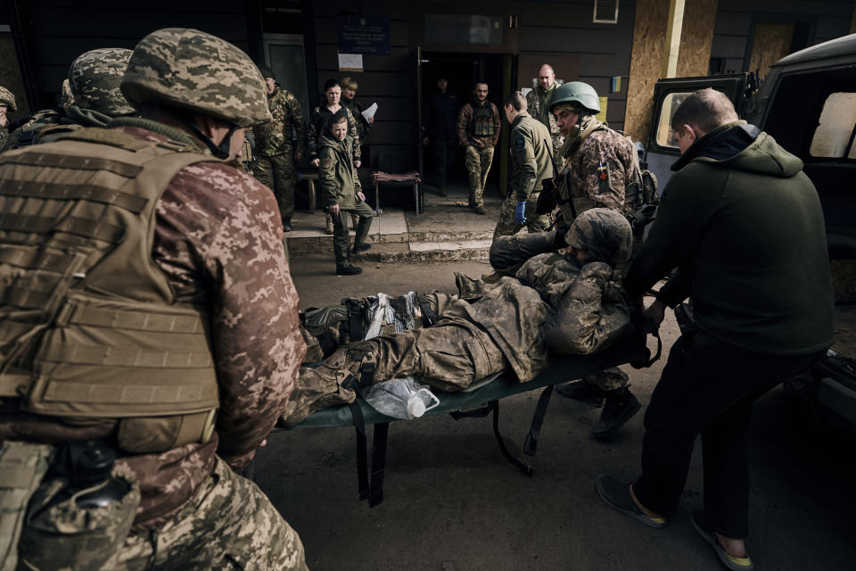 Ukrainian soldiers carry a wounded soldier into a hospital in Bakhmut, Donetsk region, Ukraine, Wednesday, Nov. 9, 2022. (AP Photo/LIBKOS)