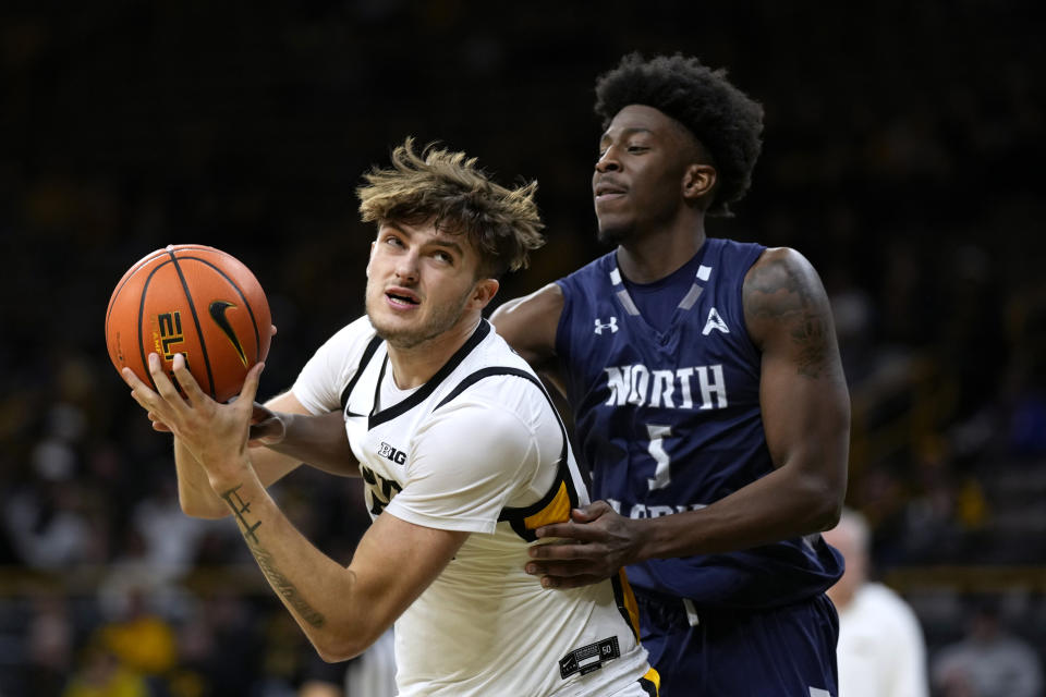 Iowa forward Owen Freeman drives around North Florida guard Dorian James, right, during the second half of an NCAA college basketball game, Wednesday, Nov. 29, 2023, in Iowa City, Iowa. (AP Photo/Charlie Neibergall)