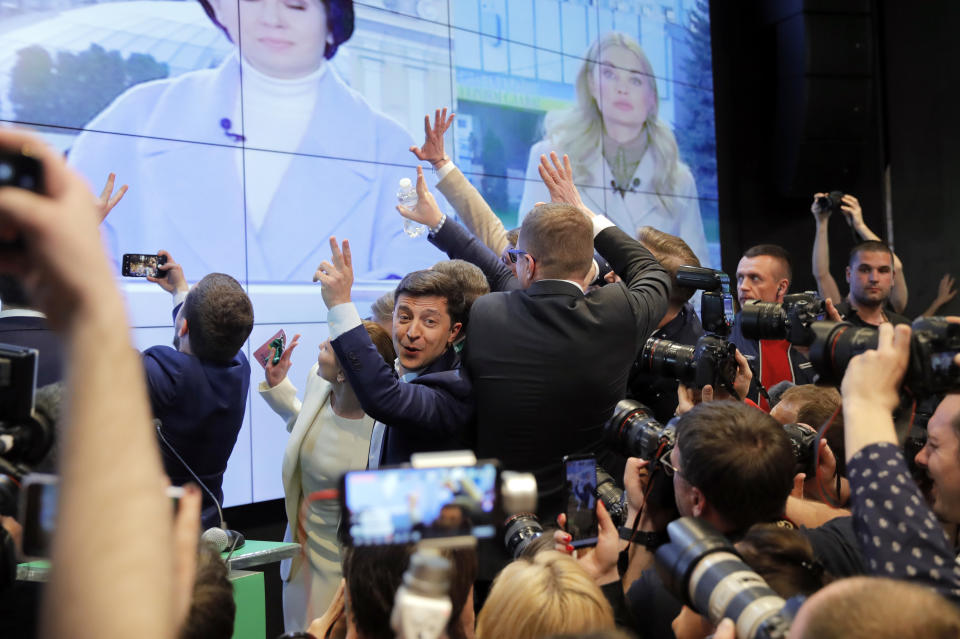 Ukrainian comedian and presidential candidate Volodymyr Zelenskiy, center, congratulates each other at his headquarters after the second round of presidential elections in Kiev, Ukraine, Sunday, April 21, 2019. Ukrainians voted on Sunday in a presidential runoff as the nation's incumbent leader struggles to fend off a strong challenge by a comedian who denounces corruption and plays the role of president in a TV sitcom. (AP Photo/Vadim Ghirda)