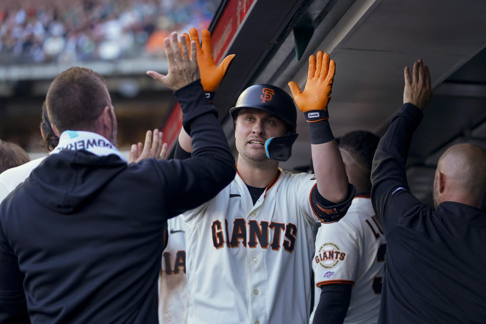 San Francisco Giants' J.D. Davis, center, celebrates with teammates in the dugout after hitting a two-run home run against the Oakland Athletics during the first inning of a baseball game Wednesday, July 26, 2023, in San Francisco. (AP Photo/Godofredo A. Vásquez)