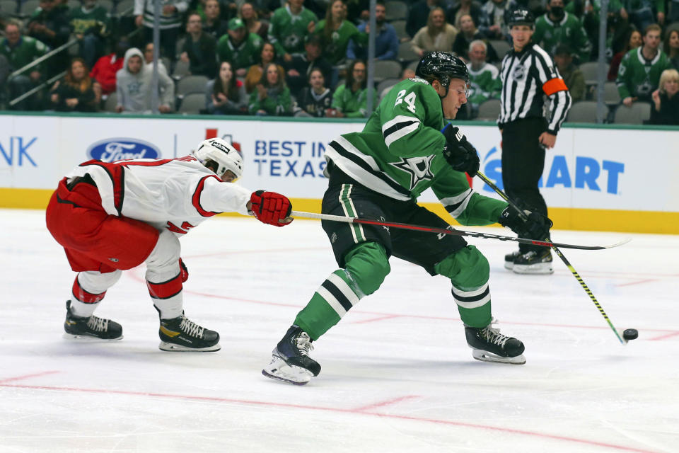 Carolina Hurricanes defenseman Maxime Lajoie (42) defends as Dallas Stars left wing Roope Hintz (24) passes the puck in the first period of an NHL hockey game Tuesday, Nov. 30, 2021, in Dallas. (AP Photo/Richard W. Rodriguez)