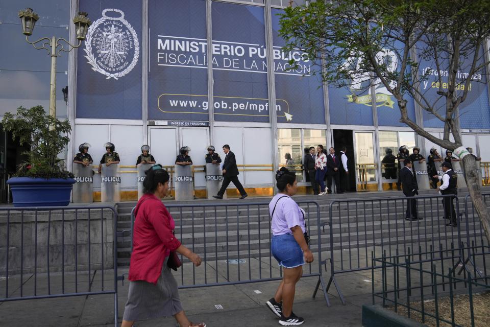 Los peatones pasan frente a la Fiscalía donde la presidenta peruana Dina Boluarte llegó a testificar en Lima, Perú, el viernes 5 de abril de 2024. (AP Foto/Martín Mejía)