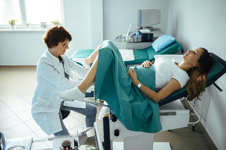 woman looking as though she's having a coil fitted by a doctor