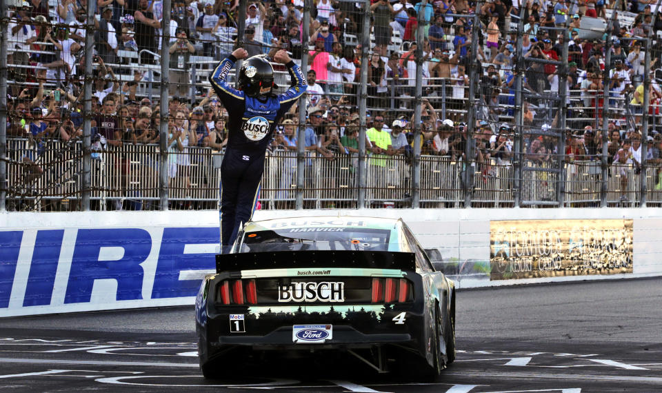 Kevin Harvick raises his arms toward fans after winning a NASCAR Cup Series auto race at New Hampshire Motor Speedway in Loudon, N.H., Sunday, July 21, 2019. (AP Photo/Charles Krupa)