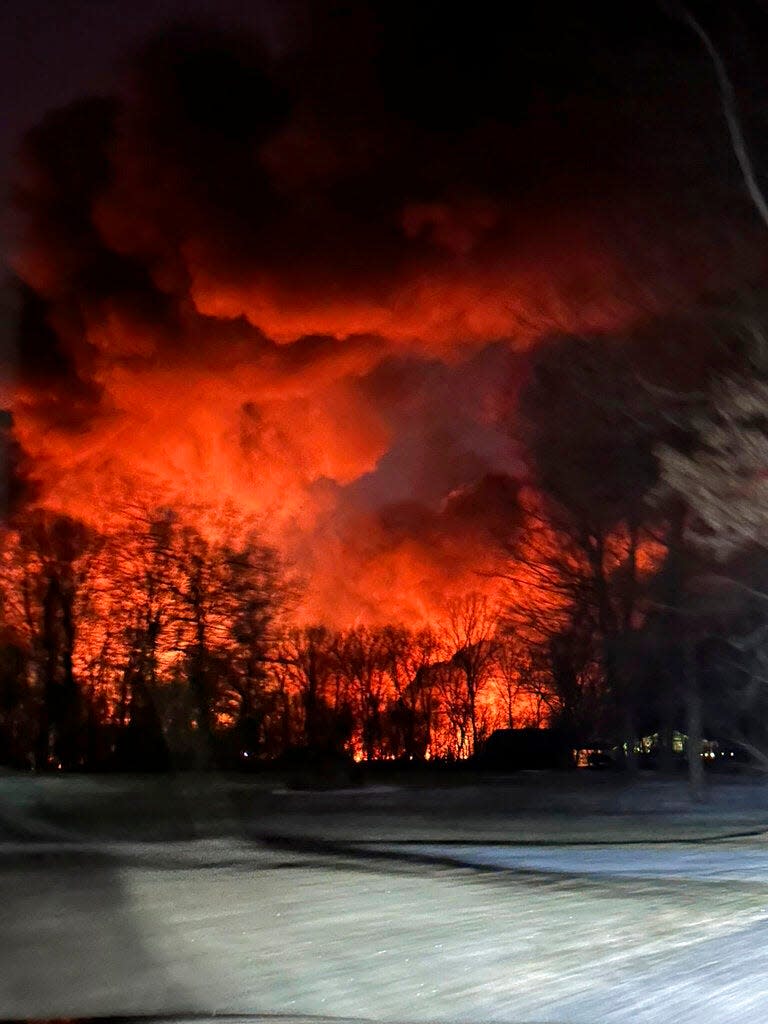 In this photo provided by Melissa Smith, a train fire is seen from her farm in East Palestine, Ohio, Friday, Feb. 3, 2023. A train derailment and resulting large fire prompted an evacuation order in the Ohio village near the Pennsylvania state line on Friday night, covering the area in billows of smoke lit orange by the flames below.