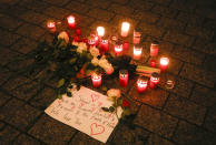 Candles and flowers placed on the floor during a vigil for victims of last night's shooting in the central German town Hanau, at the Brandenburg Gate in Berlin, Germany, Thursday, Feb. 20, 2020. A 43-year-old German man who posted a manifesto calling for the "complete extermination" of many "races or cultures in our midst" shot and several people of foreign background on Wednesday night, most of them Turkish, in an attack on a hookah bar and other sites in a Frankfurt suburb, authorities said Thursday. (AP Photo/Markus Schreiber)