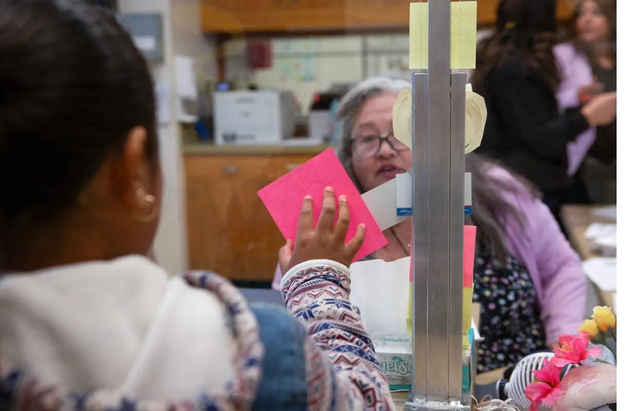 A student holds up a nurse note for Catalina Cisneros, secretary at Loma Vista Elementary School, on the first day of school in Salinas on Aug. 8, 2023.