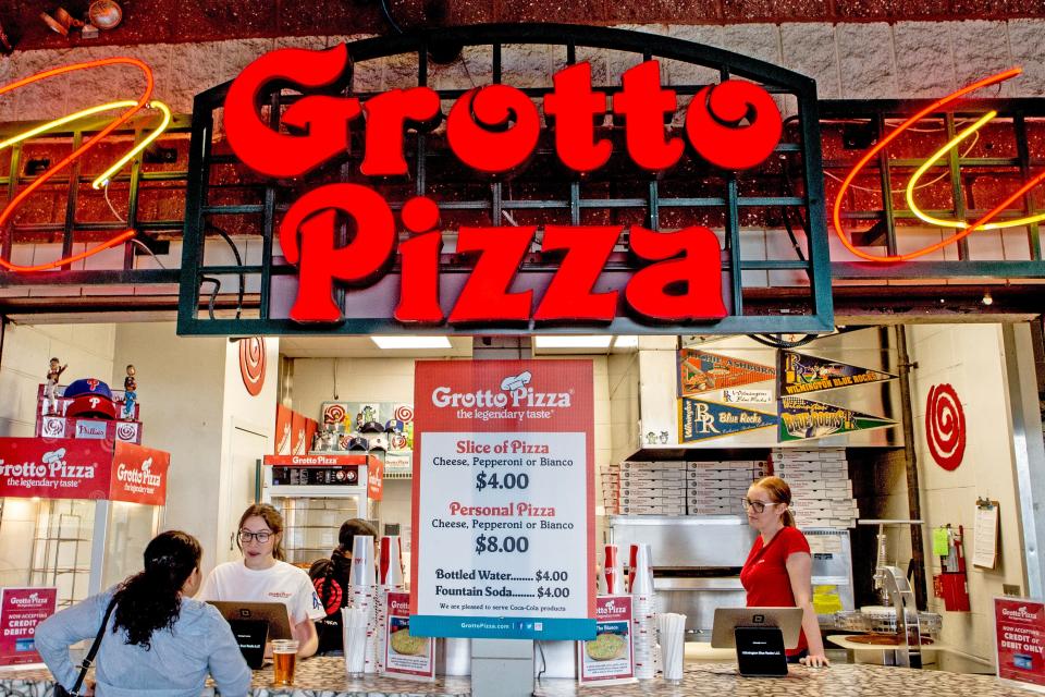 A customer purchases pizza from Grotto Pizza during the Wilmington Blue Rocks South Atlantic League home opener against the Hickory Crawdads at Frawley Stadium in Wilmington, Tuesday, April 11, 2023. Hickory won 3-2.