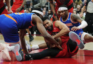 New York Knicks forward Precious Achiuwa, left, and Toronto Raptors forward Garrett Temple scramble for the ball next to Knicks guard Miles McBride during the first half of an NBA basketball game Wednesday, March 27, 2024, in Toronto. (Frank Gunn/The Canadian Press via AP)