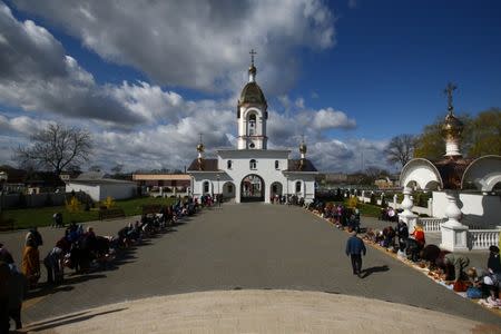 People with their Easter cakes and other food gather at an Orthodox church yard on the eve of Orthodox Easter in the village of Turov, Belarus, April 15, 2017. REUTERS/Vasily Fedosenko