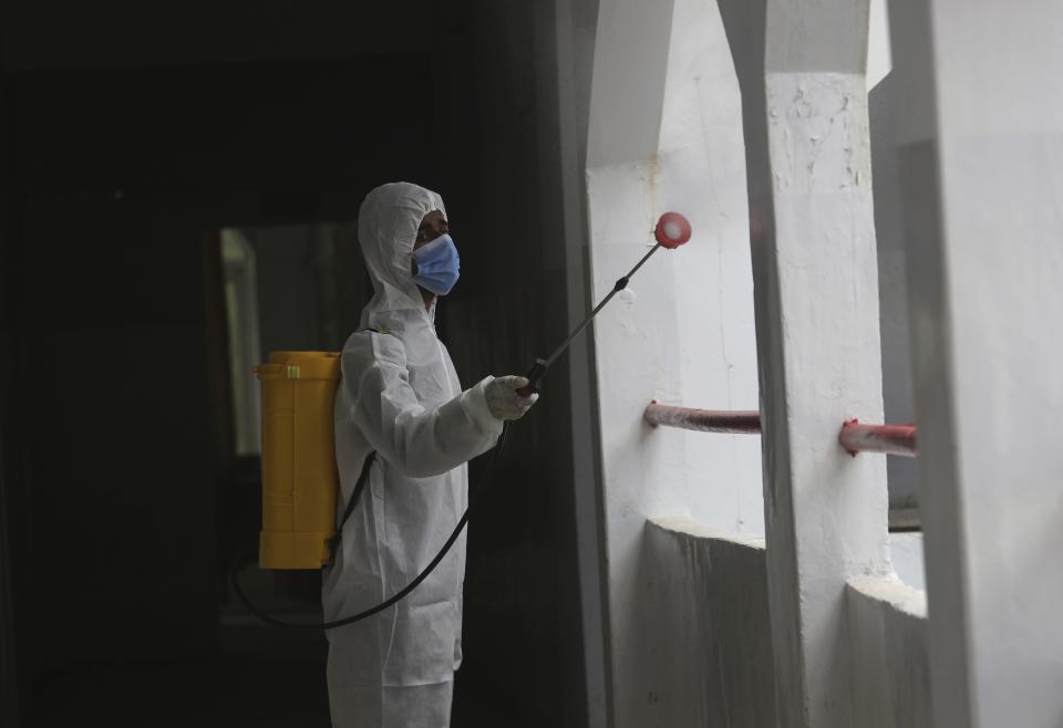 A worker sprays disinfectant in a school as preparations for reopening of educational institutions that were closed in March are finalized, in Karachi, Pakistan, Monday, Sept. 14, 2020. Education officials in Pakistan say authorities will start reopening educational institutions from Sept. 15 amid a steady decline in coronavirus deaths and infections. (AP Photo/Fareed Khan)