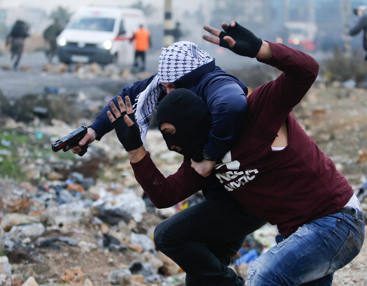 Medienberichten zufolge handelt es sich bei den vermummten Personen mit Pistolen um israelische Soldaten, die die palästinensischen Demonstranten mit Waffengewalt auseinandertreiben sollten. (Bild: AP Photo)