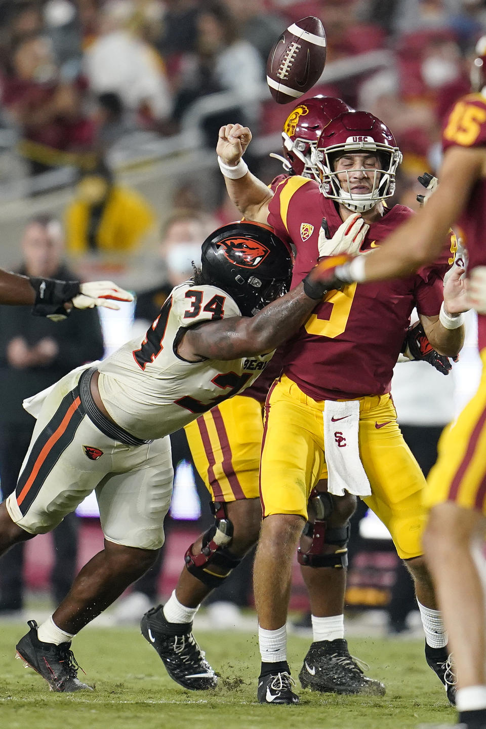 Southern California quarterback Kedon Slovis, right, loses the ball as he is hit by Oregon State linebacker Avery Roberts (34) during the second half of an NCAA college football game Saturday, Sept. 25, 2021, in Los Angeles. Oregon State recovered the ball on the play. (AP Photo/Marcio Jose Sanchez)