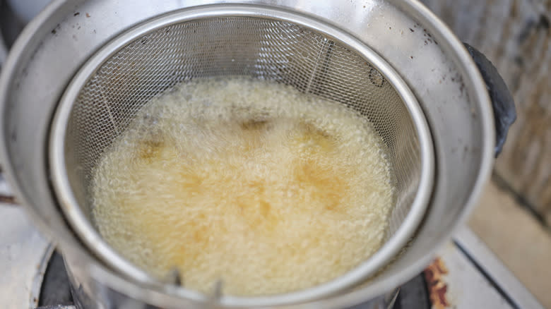 Fries cooking in spider wok skimmer