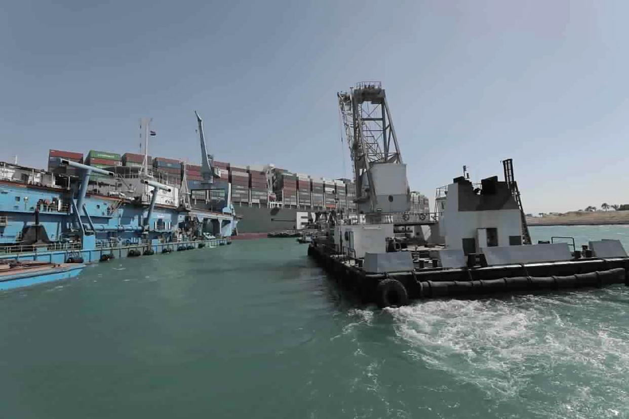 In this photo released by the Suez Canal Authority, tug boats and dredgers work to free the Panama-flagged, Japanese-owned Ever Given, which is lodged across the Suez Canal, Sunday, March 28, 2021.