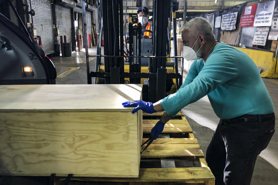 Funeral director Faheem Mian delivers the body of Mohammad Altaf, who died of COVID-19, to John F. Kennedy International Airport for shipping to Altaf's native Pakistan, Tuesday, May 19, 2020, in the Queens borough of New York. (AP Photo/John Minchillo)