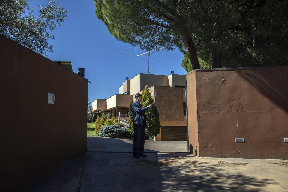 In this Wednesday, March 13, 2019 photo, a member of the North Korea's embassy tells reporters not to take pictures of the diplomatic building in Madrid, Spain. A Spanish court is accusing an American, Mexican and South Korean part of a 10-strong group that led an attack on the North Korean Embassy in February, saying the FBI was offered stolen data. National Court judge Jose de la Mata on Tuesday, March 26 lifted a secrecy order, announcing it had found evidence of various crimes, including trespassing, injuries, threats and burglary committed by "a criminal organization." (AP Photo/Bernat Armangue)