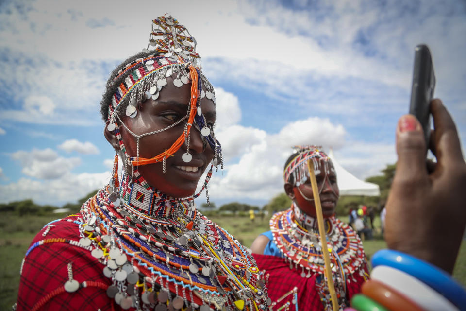 A Maasai woman takes a selfie as she prepares to watch the Maasai Olympics in Kimana Sanctuary, southern Kenya Saturday, Dec. 10, 2022. The sports event, first held in 2012, consists of six track-and-field events based on traditional warrior skills and was created as an alternative to lion-killing as a rite of passage. (AP Photo/Brian Inganga)