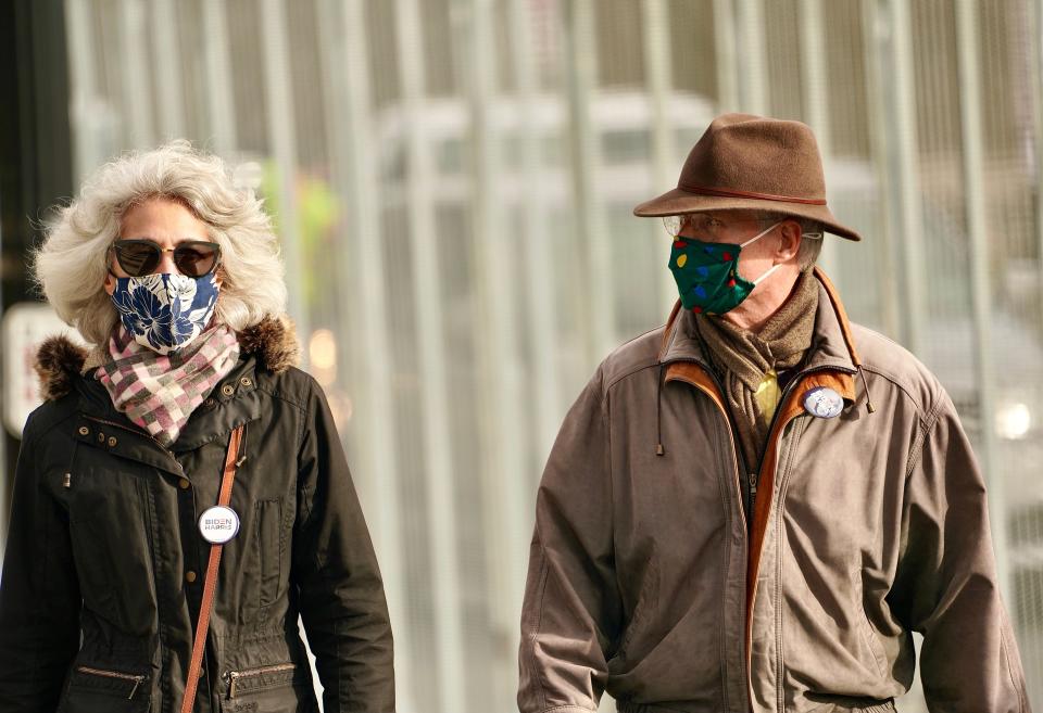 District of Columbia residents Charles and Gina Hall walk past security fencing near the Lincoln Memorial on Jan. 17. The two, wearing Biden/Harris buttons, said they normally walk in the area and wanted to see the security measures in place. The nation's capital is on high alert under heightened security against threats to President-elect Joe Biden’s inauguration after the deadly pro-Trump insurrection at the U.S. Capitol.