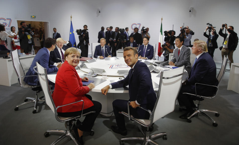 French President Emmanuel Macron, center, U.S. President Donald Trump, right, Japan's Prime Minister Shinzo Abe, second right, Britain's Prime Minister Boris Johnson, second left, German Chancellor Angela Merkel , center left, Canada's Prime Minister Justin Trudeau, Italy's Prime Minister Giuseppe Conte, rear right, and European Council President Donald Tusk attend a G7 working session on "International Economy and Trade, and International Security Agenda" during the G7 summit in Biarritz, southwestern France, Saturday Aug. 25, 2019. (Philippe Wojazer/Pool via AP)