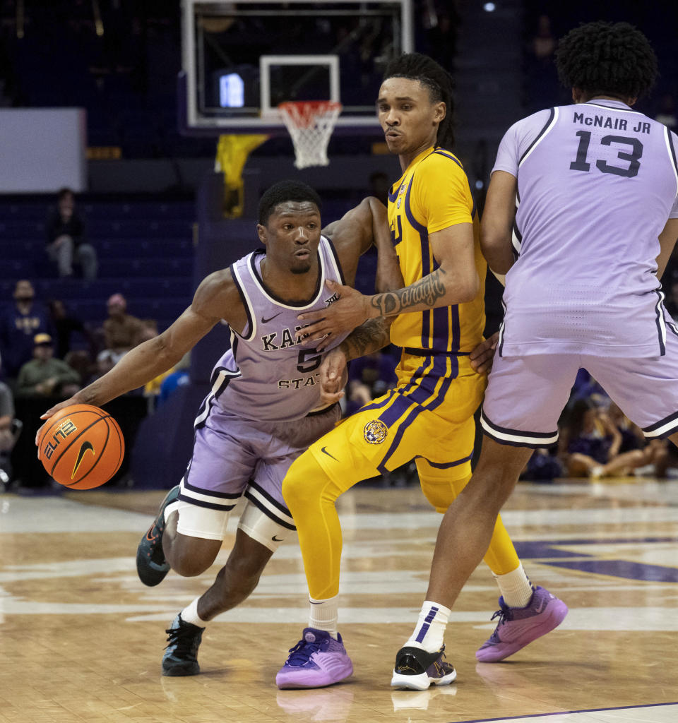 Kansas State guard Cam Carter (5) drives around LSU forward Tyrell Ward (15) as Kansas State center Will McNair Jr. (13) sets up the screen during an NCAA college basketball game, Saturday, Dec. 9, 2023, in Baton Rouge, La. (Hilary Scheinuk/The Advocate via AP)