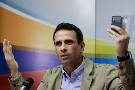 El líder de la oposición venezolana y gobernador del central estado Miranda, Henrique Capriles, sostiene una copia de la Constitución de Venezuela, mientras habla con los medios durante una conferencia de prensa en Caracas, Venezuela, 2 de mayo de 2017. REUTERS/Marco Bello