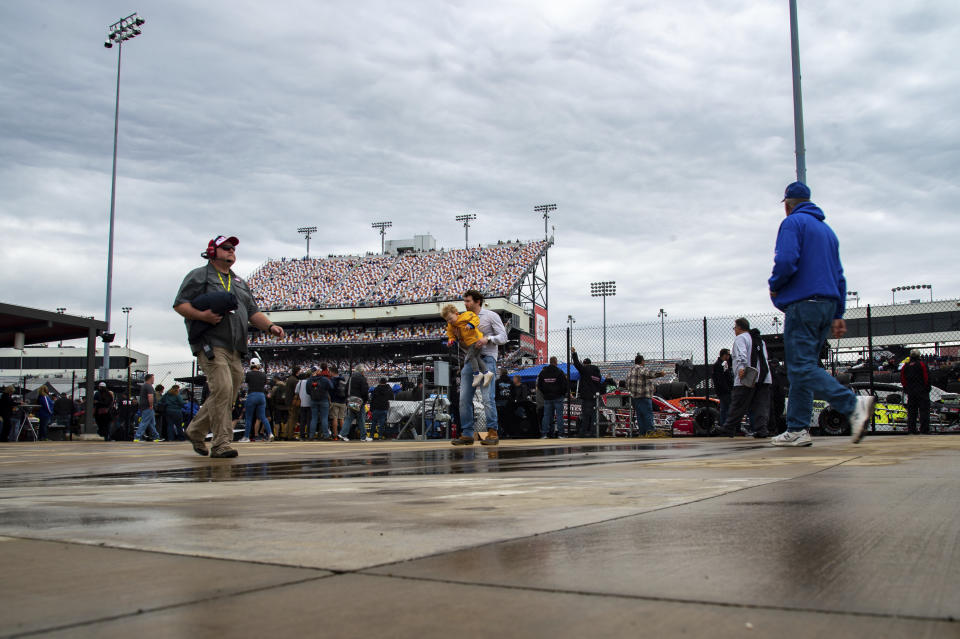 Fans walk around during a rain delay as they wait for the start of the NASCAR Xfinity Series auto race at Richmond Raceway, Saturday, April 1, 2023, in Richmond, Va. (AP Photo/Mike Caudill)
