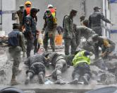 Rescuers and volunteers search for survivors amid the rubble and debris of a collapsed building