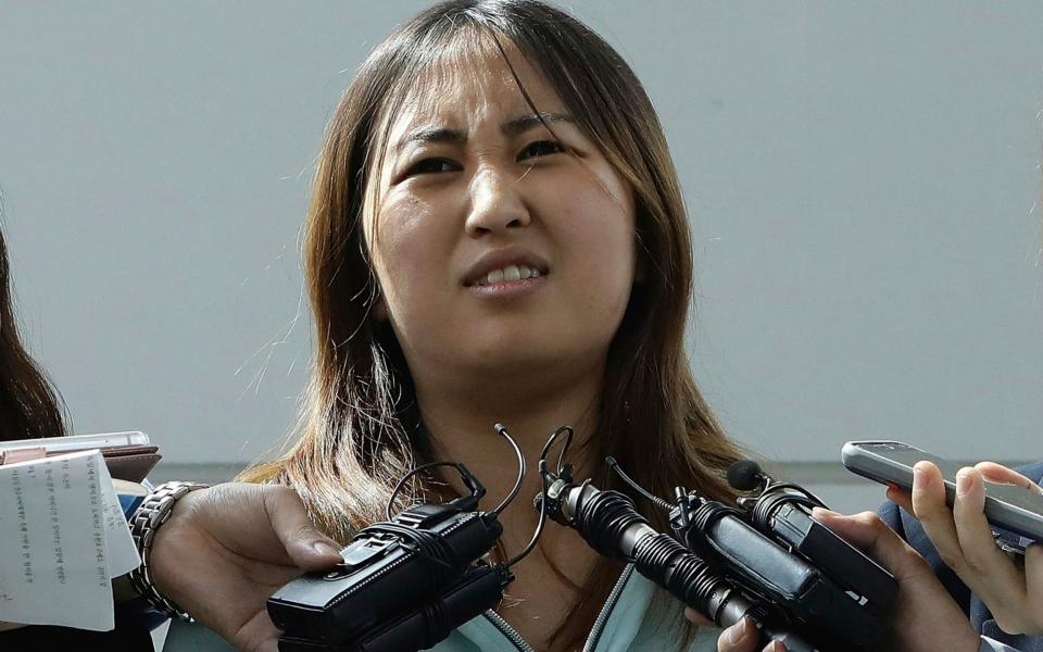 Chung Yoo-ra, center, the daughter of Choi Soon-sil, answers questions from the media after her arrival at the Incheon International Airport Wednesday, May 31 - Credit:  Chung Sung-Jun/Getty Images