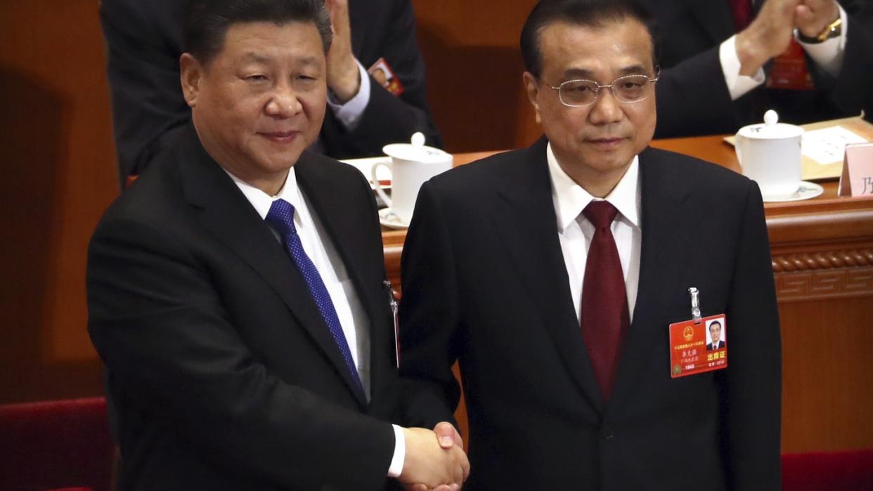 Präsident Xi Jinping gratuliert Li Keqiang zu seiner Wiederwahl als Premierminister von China. Foto: Mark Schiefelbein/AP