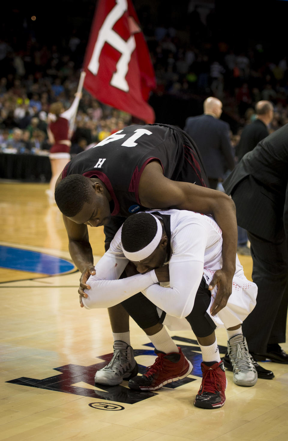 Harvard forward Steve Moundou-Missi (14) consoles Cincinnati foward Justin Jackson after the Harvard defeated Cincinnati 61-57 in the second round of the NCAA men's college basketball tournament in Spokane, Wash., Thursday, March 20, 2014. (AP Photo/The Spokesman-Review, Colin Mulvany) COEUR D'ALENE OUT