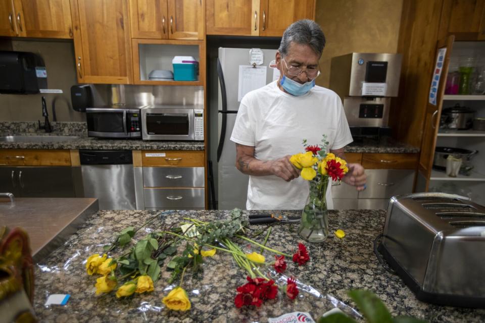 Jesse Gallegos arranges a vase of flowers at the Inn Between.