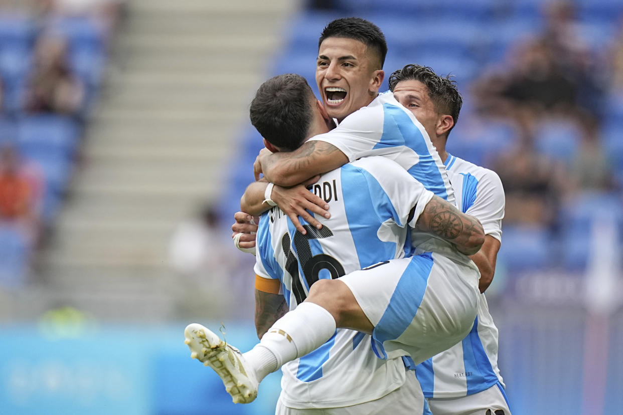 Argentina's Thiago Almada celebrates with Nicolas Otamendi scoring his side's opening goal against Ukraine during the men's Group B soccer match at the Lyon stadium during the 2024 Summer Olympics on July 30, 2024, in Decines, France. (Laurent Cipriani/AP)