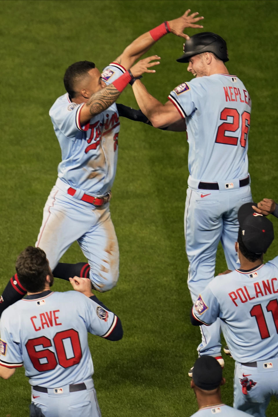 Minnesota Twins' Eddie Rosario, top left, and Max Kepler, top right, celebrate Kepler's single off Detroit Tigers pitcher Bryan Garcia that drove in Rosario for the winning run in the 10th inning of a baseball game Tuesday, Sept. 22, 2020, in Minneapolis. The Twins won 5-4. (AP Photo/Jim Mone)