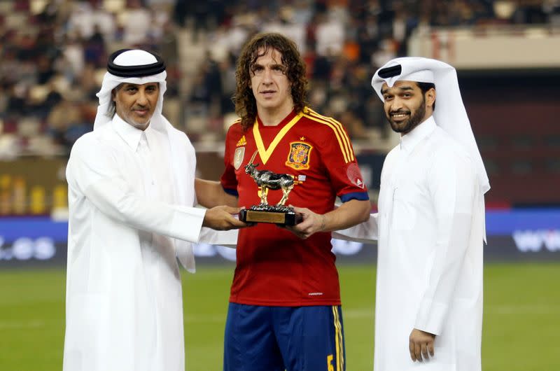 FILE PHOTO: Spain's Puyol receives a trophy for his 100th international game at their international friendly soccer match against Uruguay in Doha