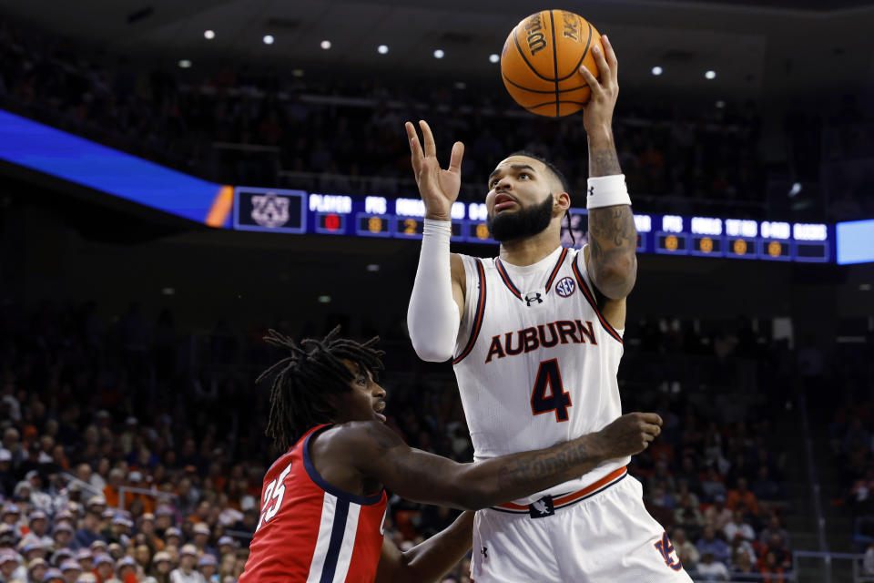 Auburn forward Johni Broome (4) shoots next to Mississippi forward Rashaud Marshall (25) during the second half of an NCAA college basketball game Saturday, Jan. 20, 2024, in Auburn, Ala. (AP Photo/Butch Dill)