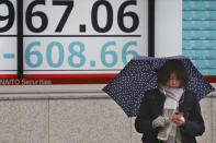 A woman stands in front of an electronic stock board of a securities firm in Tokyo, Wednesday, Jan. 8, 2020. Oil prices rose and Asian stock markets fell Wednesday after Iran fired missiles at U.S. bases in Iraq in retaliation for the killing of an Iranian general. Tokyo's stock market benchmark fell nearly 2%.(AP Photo/Koji Sasahara)