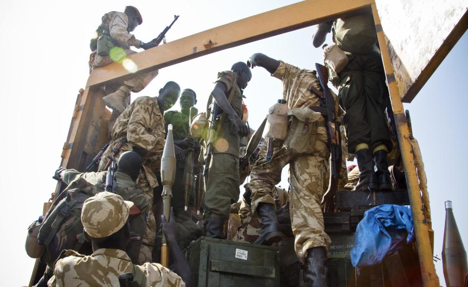 Some of hundreds of government soldiers board various vehicles, as they prepare to travel towards the frontline, to reinforce government forces already fighting rebel forces near the town of Bor, as they prepare to leave from the outskirts of Juba, South Sudan, Monday, Jan. 13, 2014. Despite the appearance of diplomatic progress, the conflict seems set to continue as South Sudan government troops are moving in on Bor which is currently held by rebels. (AP Photo/Jake Simkin)