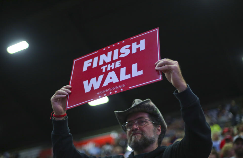 A supporter holds up a sign which reads, "FINISH THE WALL" as he waits to hear President Donald Trump speak at a campaign rally at WesBanco Arena, Saturday, Sept. 29, 2018, in Wheeling, W.Va. (AP Photo/Pablo Martinez Monsivais)