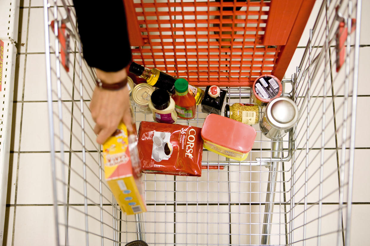 Shopper placing groceries in shopping cart Getty Images/PhotoAlto/James Hardy
