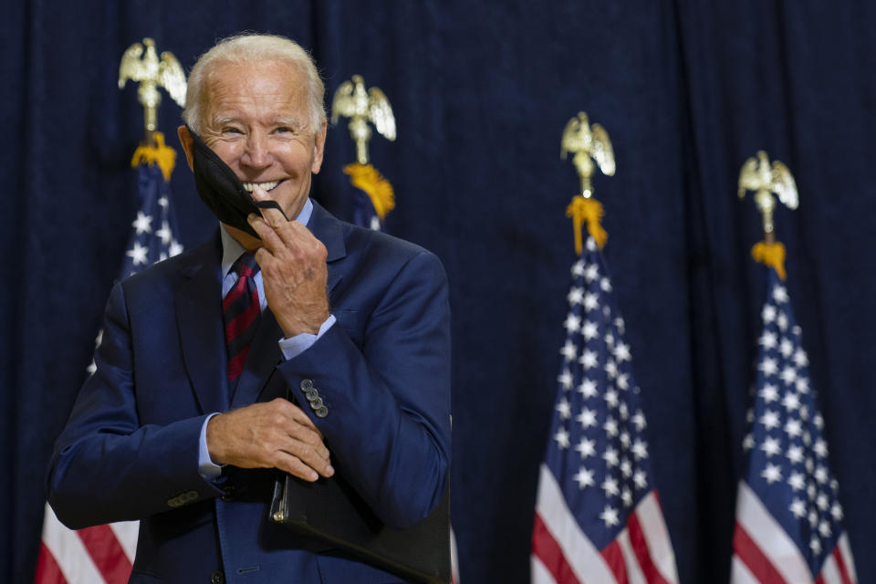 FILE - Democratic presidential candidate former Vice President Joe Biden smiles as he puts on his face mask after speaking to media in Wilmington, Del., on Sept. 4, 2020. (AP Photo/Carolyn Kaster, File)