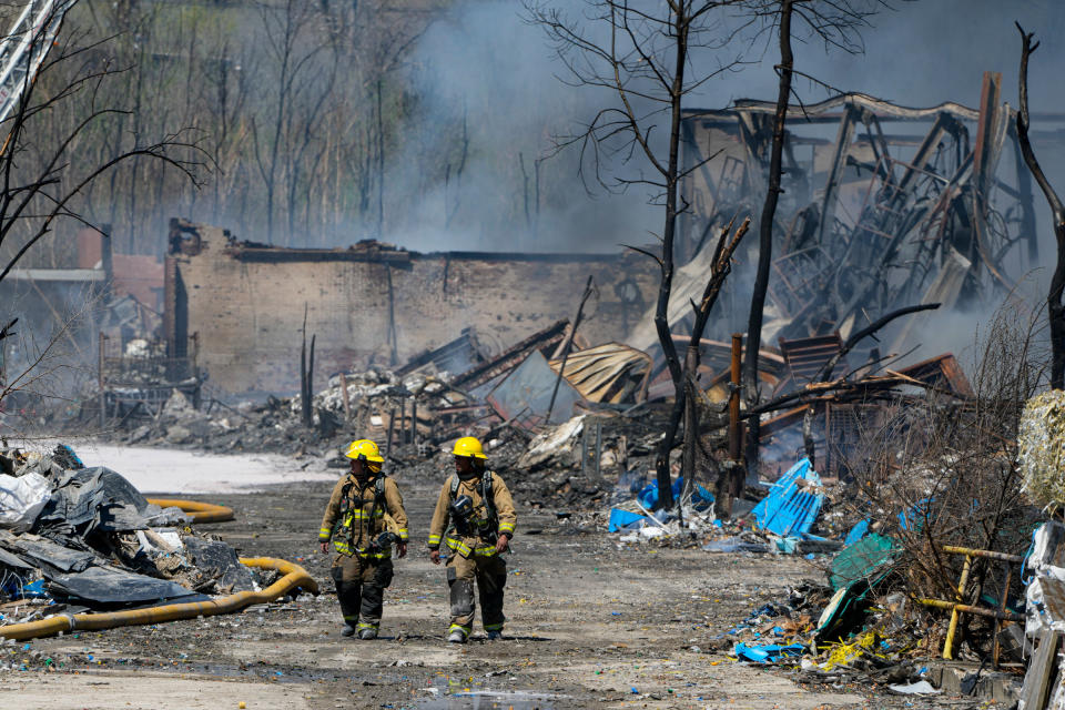 Firefighters walk out of the site of an industrial fire in Richmond, Ind., on April 12, 2023.<span class="copyright">Michael Conroy—AP</span>