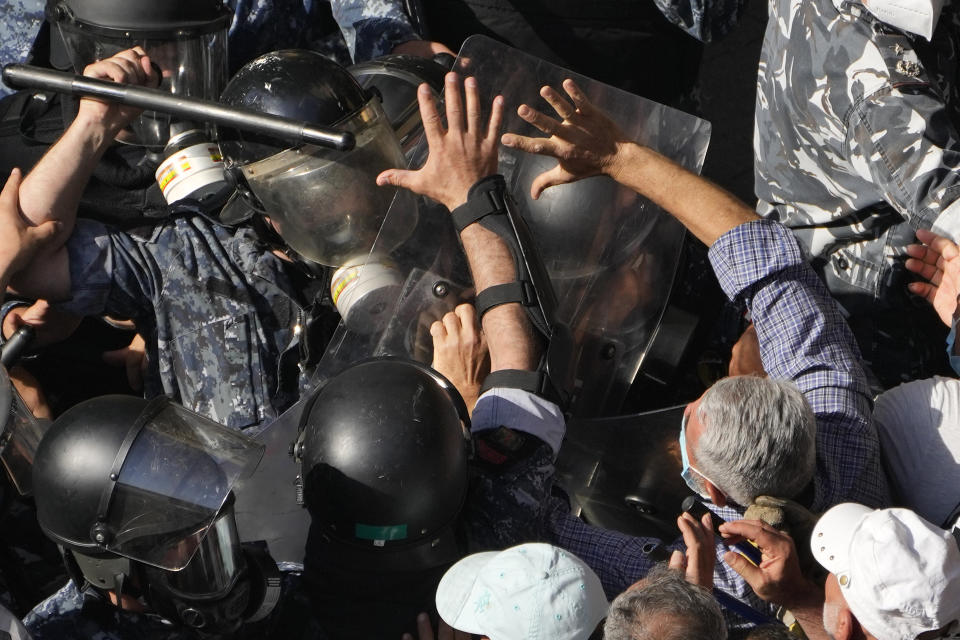 Retired members of the Lebanese security forces, clash with riot police during a protest demanding better pay and living conditions in Beirut, Lebanon, Tuesday, April 18, 2023. Earlier in the day, Lebanon's Parliament voted to postpone municipal elections that had been planned for May 2023 in the crisis-stricken country by up to a year. (AP Photo/Hussein Malla)