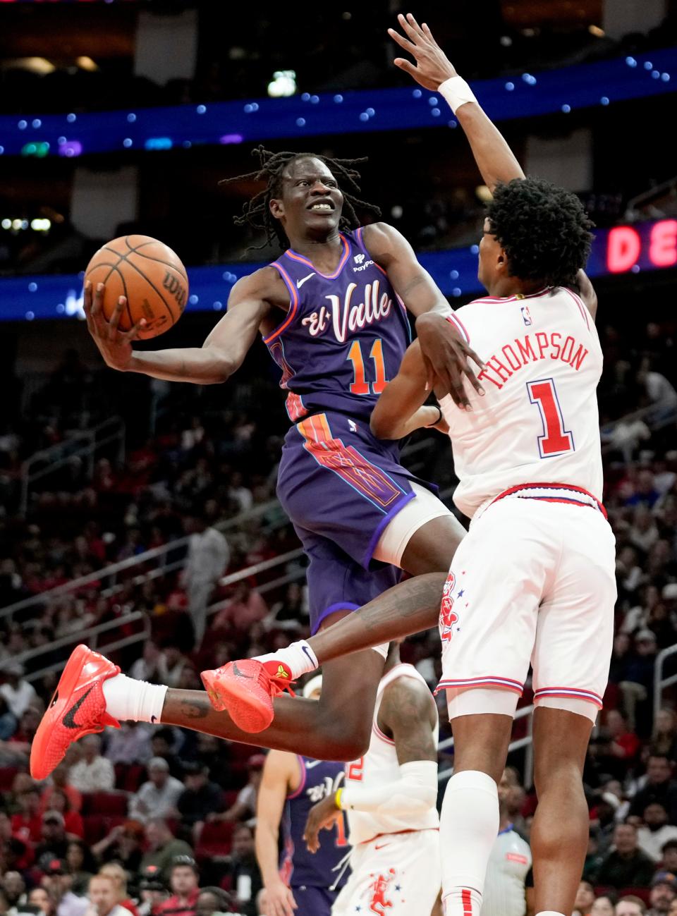 Phoenix Suns center Bol Bol (11) drives to the basket as Houston Rockets forward Amen Thompson (1) defends during the first half of an NBA basketball game Friday, Feb. 23, 2024, in Houston.