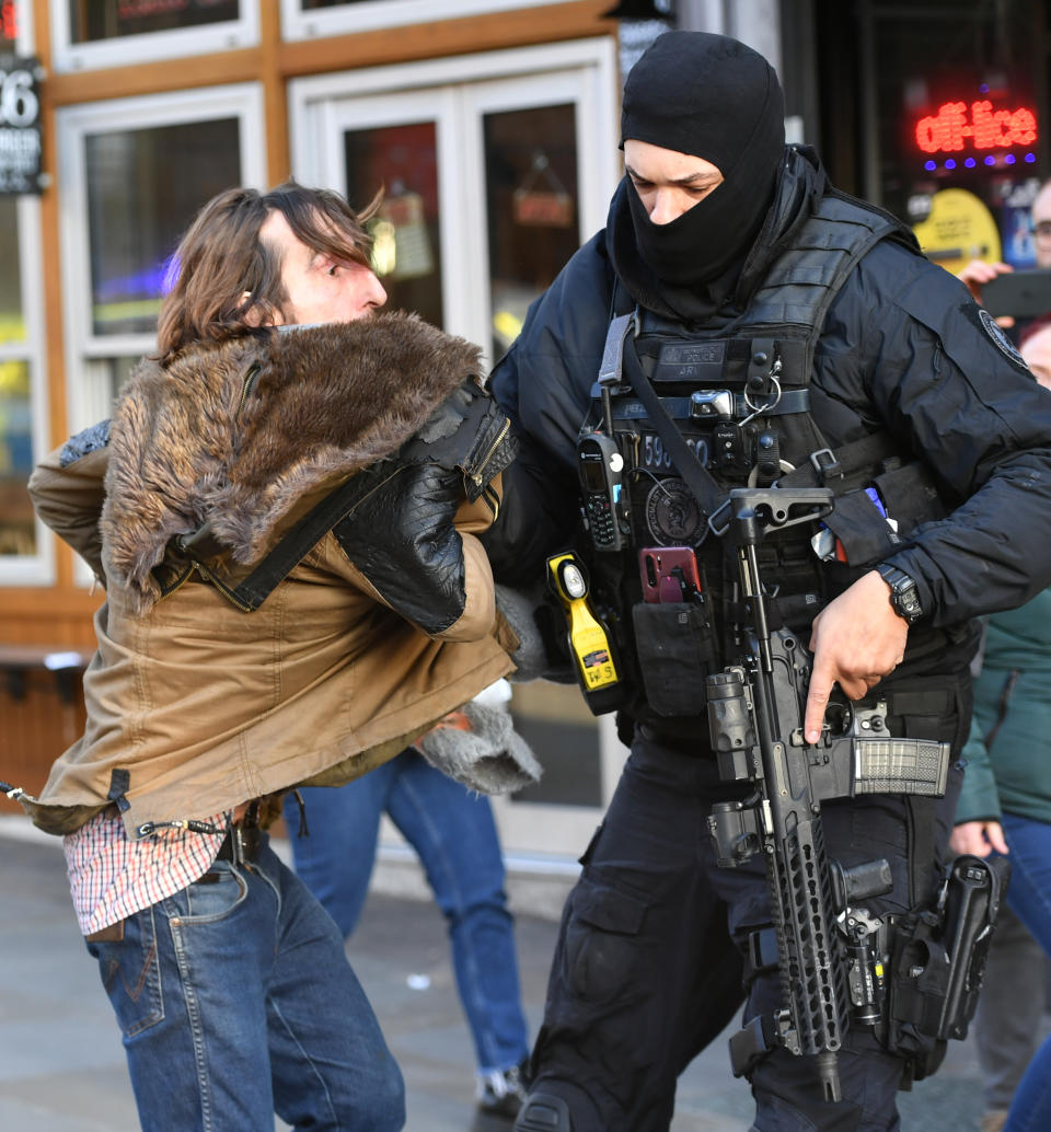 A police officer moves an uninvolved person away from a cordon after an incident on London Bridge in central London.