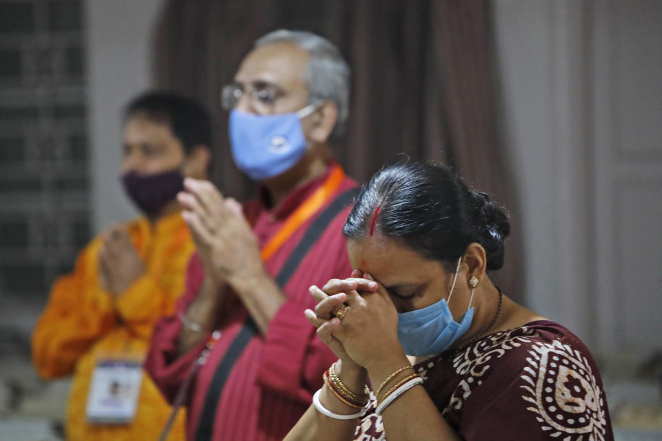 Members of the festival organizing team at the Kali Bari Hindu temple pray via live transmission on the first day of Durga Puja celebrations in New Delhi, India, Thursday, Oct. 22, 2020. Most of the festival festivities are being scaled down following the health officials warning about the potential for the coronavirus to spread during the religious festival season, which is marked by huge gatherings in temples and shopping districts. (AP Photo/Manish Swarup)